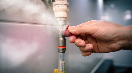 Hand turning off a leaking gas valve with visible vapour escaping — symbolising a gas leak or safety issue.